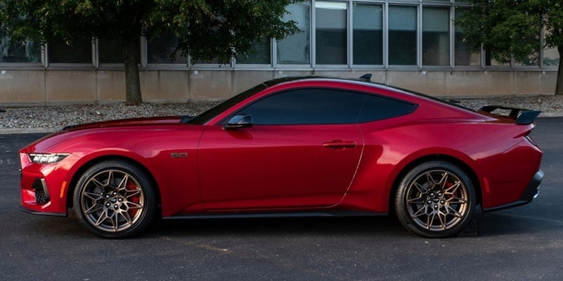 Red 2024 Ford Mustang side view in parking lot